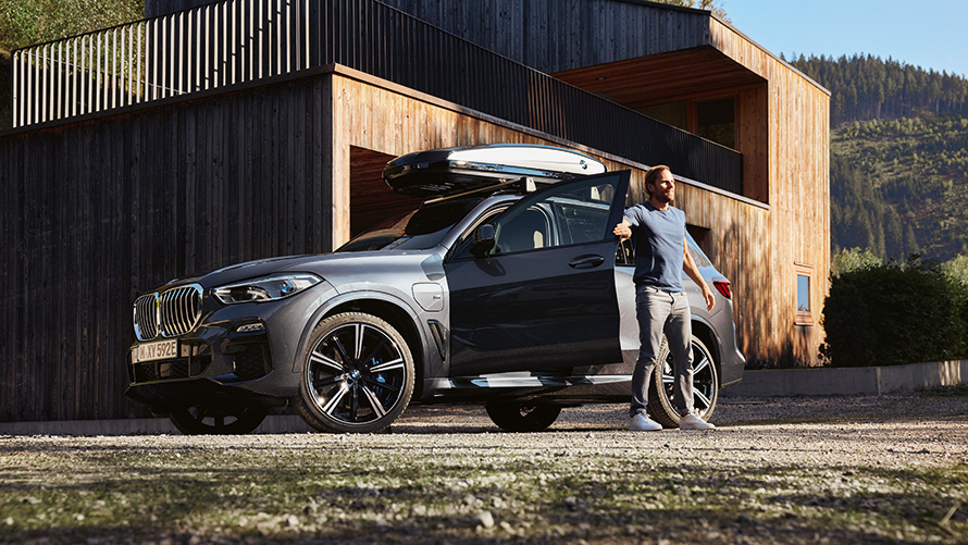 Mies poistumassa BMW-autostaan kesäillassa.